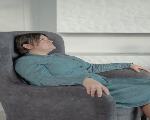 Osoba oddychająca głęboko w domowym fotelu